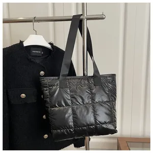 Primer plano del bolso tote acolchado negro brillante con diseño de cuadros grandes