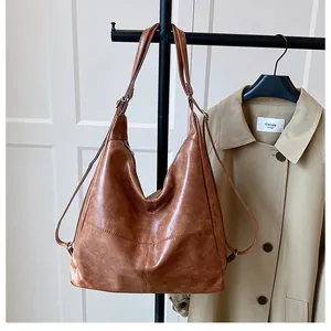 Detail of vintage caramel brown hobo bag showing faux leather texture and adjustable straps