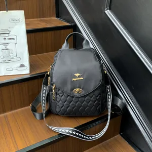Chic black quilted backpack with kangaroo logo on wooden stairs and patterned strap