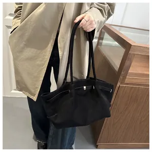 Detailed macro view of black matte tote bag with thin straps and metallic buckle detail