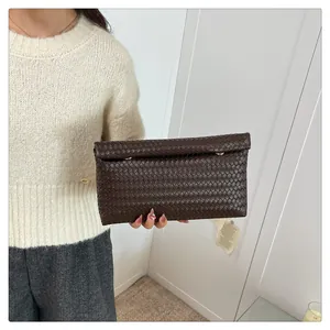 Detailed view of dark brown woven leather texture and elegant golden metal clasps