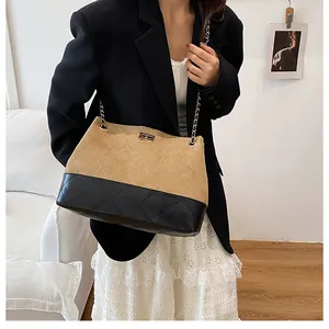Détail du sac cabas contrasté avec motif à losanges surpiqués et fermoir doré