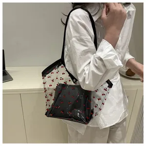 Detail of transparent PVC tote bag featuring cherry print and black inner pouch