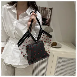 Detail of transparent PVC tote bag with red cherry prints and black inner pouch