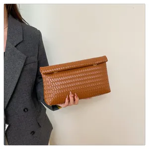 Detail of a brown woven texture clutch bag featuring high-quality synthetic leather craftsmanship