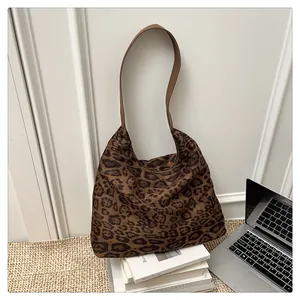 Detailed view of the leopard print tote bag with a laptop and magazine in a room