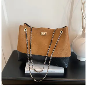 Détail du sac cabas bicolore avec daim matelassé et fermoir pivotant en métal doré