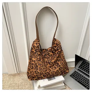 Macro detail of high-capacity leopard print tote bag with brown faux leather straps