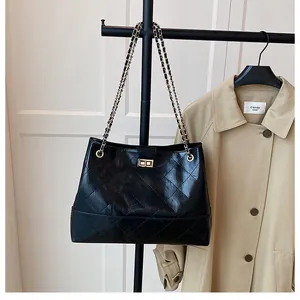Détail du grand sac cabas noir matelassé avec fermoir doré et bandoulière chaîne