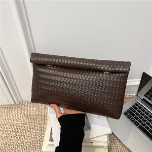 Brown woven leather clutch bag with gold rings for business and casual use