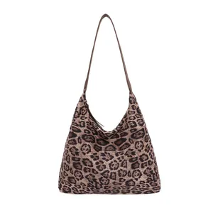 Fashionable leopard print hobo tote bag with a brown leather strap on white background