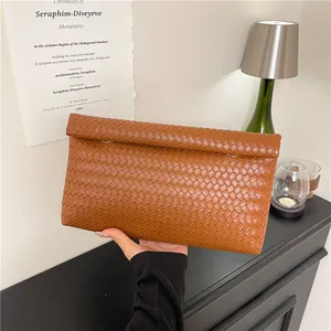 Brown woven leather clutch bag with a fold-over design for elegant business commuting