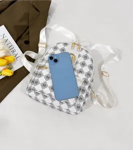 Mini backpack with M-pattern and gold hardware compared to a smartphone for size reference