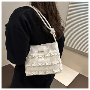 Detail of cream lace tote bag featuring triple-layer ruffles and golden JINGPIN logo