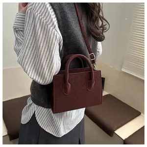 Details einer weinroten Handtasche mit Leopardenmuster und goldenen Beschlägen