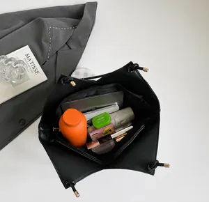 Top-down view of large black tote bag interior showing capacity for tablets and umbrellas