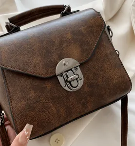 Detail van de bruine vintage leertextuur en zilveren metalen draaisluiting van de tas
