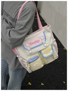 Detail of color-block canvas shoulder bag featuring multiple pockets and pastel design