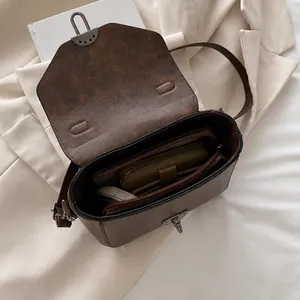 Bovenaanzicht van de binnenzijde van de bruine retro tas met vakken en ritszak voor opslag