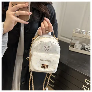 Mirror selfie showing the polka dot mini backpack with chain strap on a model