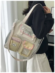 Detail of multi-pocket canvas shoulder bag with pastel color-block design and adjustable strap