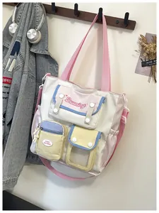 Detail of multi-pocket canvas shoulder bag featuring pastel patchwork and magnetic snaps