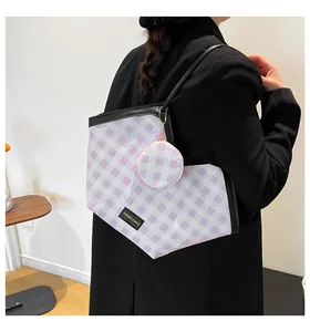Detail of purple gingham tote bag with mini coin purse shown on female model's shoulder