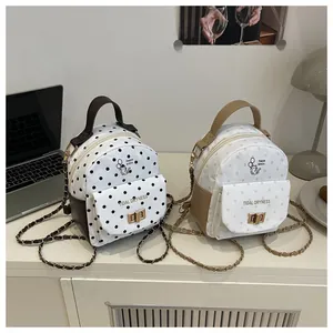 Detailed view of polka dot mini backpacks with cat graphics and golden metal turn-locks