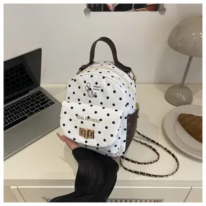 Close-up of polka dot mini backpack with cat print and metal chain strap details