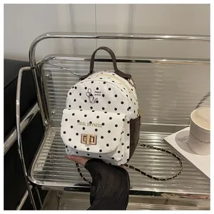Polka dot mini backpack featuring chain straps and cute cat print in a casual setting