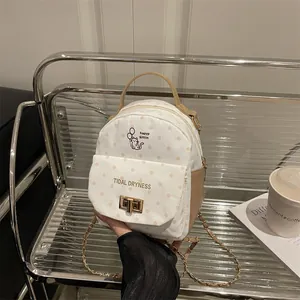 Polka dot mini backpack with kitten illustration and gold metal clasp on display