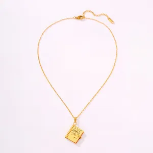 Macro detail of 18k gold plated book pendant with heart cutout and fine O-chain
