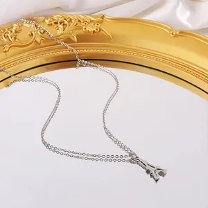 Elegante collar de la Torre Eiffel en acero de titanio sobre bandeja de espejo