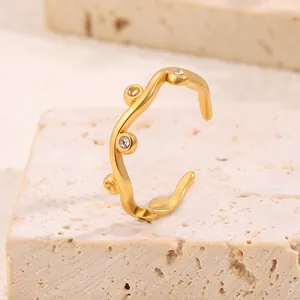 Detailed macro shot of irregular wave gold titanium ring with shimmering crystal studs