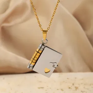 Détail d'un pendentif enveloppe bicolore avec découpe en cœur sur un tissu satiné
