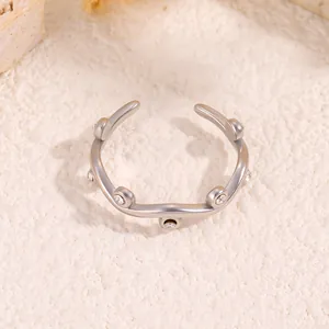 Detail of silver wavy titanium steel ring featuring multiple pavé zircon stones