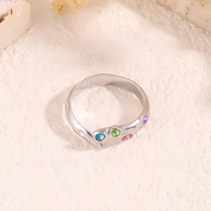 Gros plan de la bague en acier titane argenté avec texture ondulée et cristaux colorés