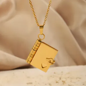 Gros plan du pendentif enveloppe doré avec découpe en cœur sur soie et support en pierre
