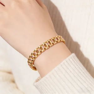 Detalle de una pulsera dorada estilo reloj con circonitas rosas en la muñeca