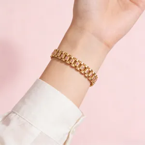 Detalle de una pulsera dorada estilo correa con circones rosas usada por una modelo mujer