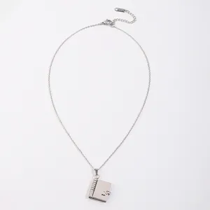 Détail du pendentif enveloppe en argent avec gravure K18 et motif musical