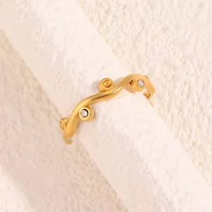 Close-up of golden irregular wavy ring with sparkling pavé crystals and matte finish
