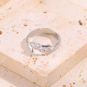 Gros plan d'une bague irrégulière en acier titane argenté avec quatre zircons clairs