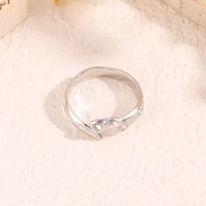Détail d'une bague irrégulière en acier titane argenté avec incrustation de zircons