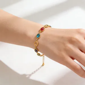 Primer plano de pulsera bañada en oro de 18K con circonitas de colores en muñeca