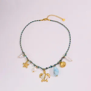 Detail van bohemien geweven ketting met stalen zeebedels en schelpkralen op wit