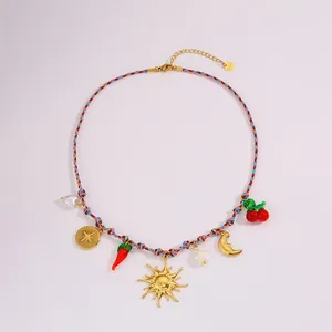 Detail van de bohemian gevlochten ketting met zon-, hart- en kersenhangers