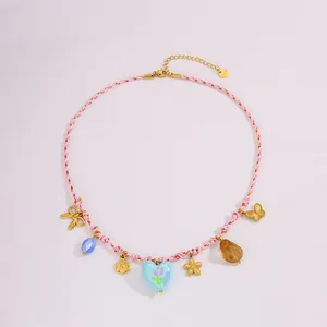 Detail van de kleurrijke gevlochten touwketting met boho bedels en hart hanger