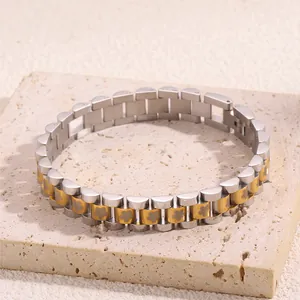 Detailed macro view of two-tone steel flower link bracelet on a textured stone surface