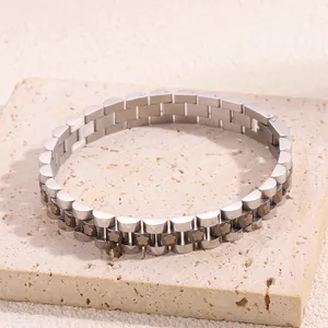 Macro shot of stainless steel chain bracelet with floral details on stone tray